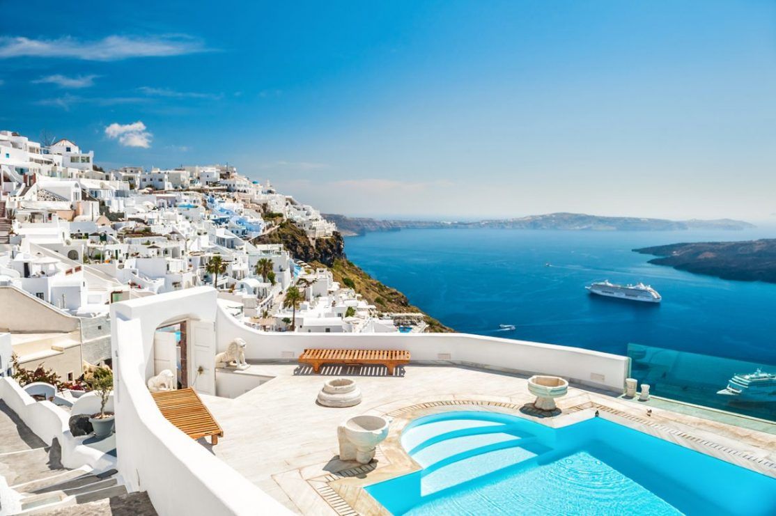 White architecture on Santorini island, Greece. Swimming pool in luxury hotel. Beautiful view on the sea.